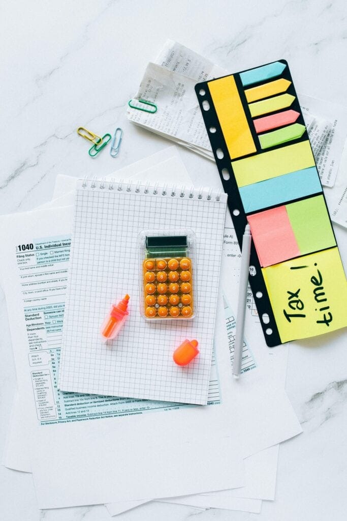 多彩的收納夾在整理票據與文件，搭配計算器和稅務表格，呈現專業財務整理與稅務申報的工作場景。.