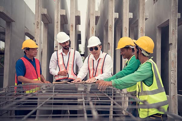 工地施工現場的外籍建築工人與管理人員討論工程細節.