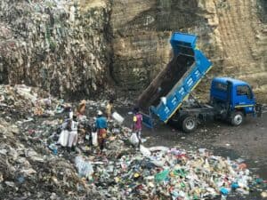 垃圾清理車在山區垃圾堆積地清掃環境，展現21世紀外勞團隊的辛勤勞動與合作。.