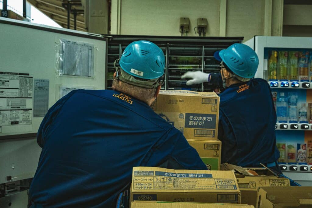 帶安全帽的物流倉庫工人正在搬運貨物.